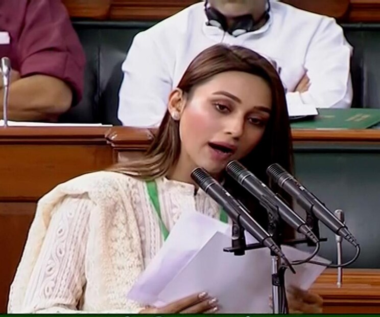 • রবিবার ভোর রাতে কলকাতায় পৌঁছনোর পর মঙ্গলবার সকালে লোকসভায় শপথ গ্রহণ করলেন নুসরত ৷ বন্ধুর বিয়েতে উপস্থিত থাকতে গিয়ে শপথের দিন সংসদে হাজিরা দিতে পারেননি যাদবপুর লোকসভা কেন্দ্র থেকে জয়ী তৃণমূলের সাংসদ মিমি চক্রবর্তীও ৷ (Image: LSTV/PTI)
