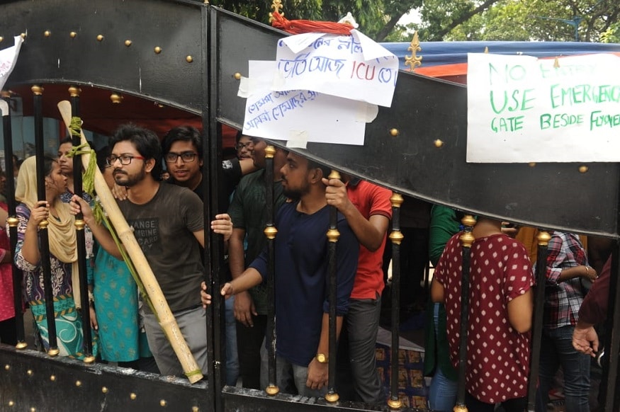 হাসপাতাল চত্বরেই বিক্ষোভে সামিল ইনটার্ন ও জুনিয়র ডাক্তাররা। আন্দোলনে যোগ দিলেন হাসপাতালের সিনিয়র ডাক্তাররাও। (Image: Sujit Nath, News18) হাসপাতাল চত্বরেই বিক্ষোভে সামিল ইনটার্ন ও জুনিয়র ডাক্তাররা। আন্দোলনে যোগ দিলেন হাসপাতালের সিনিয়র ডাক্তাররাও। (Image: Sujit Nath, News18)