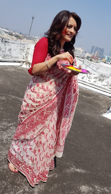 লালা পাড়ে সাদা ঢাকাই শাড়ি পরে হাতে রঙের থালা নিয়ে ঊষসী 