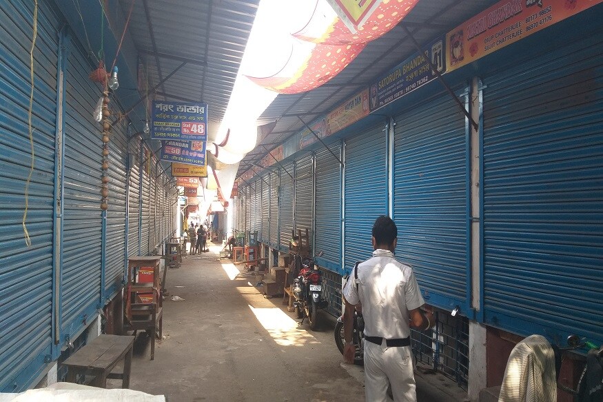 পুজোর ডালা সাজিয়ে যেসব দোকানগুলো কালীঘাট মন্দির চত্বরে বসে থাকে তাদের একটিও খোলা নেই পয়লা বৈশাখের সকালে। দূরে দুয়েকটি দোকান খোলা। তবে ক্রেতা নেই। হাতেগোনা কয়েকজন মানুষ আসছেন লক্ষ্মী, গণেশ নিয়ে ঝুড়িতে। পুজোর ডালা সাজিয়ে যেসব দোকানগুলো কালীঘাট মন্দির চত্বরে বসে থাকে তাদের একটিও খোলা নেই পয়লা বৈশাখের সকালে। দূরে দুয়েকটি দোকান খোলা। তবে ক্রেতা নেই। হাতেগোনা কয়েকজন মানুষ আসছেন লক্ষ্মী, গণেশ নিয়ে ঝুড়িতে।
