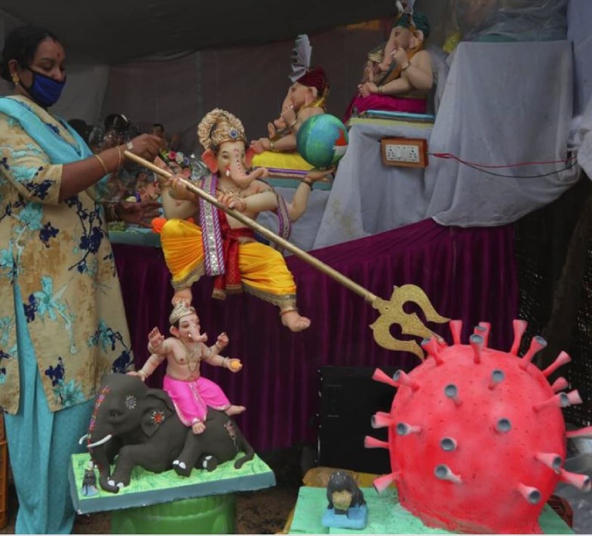 মূর্তি বিক্রি না হওয়ার সমস্যায় পড়েছেন মৃৎ শিল্পীরা। মুখে মাস্ক পড়ে গণেশের মূর্তিতে শেষ তুলির টান আঁকছেন হায়দরাবাদের শিল্পী। Image: AP মূর্তি বিক্রি না হওয়ার সমস্যায় পড়েছেন মৃৎ শিল্পীরা। মুখে মাস্ক পড়ে গণেশের মূর্তিতে শেষ তুলির টান আঁকছেন হায়দরাবাদের শিল্পী। Image: AP