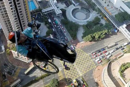 Lai Chi-wai, a paraplegic climber, attempts to climb the 320-metre tall Nina Tower using only his upper body strength, in Hong Kong, China. REUTERS/Tyrone Siu