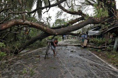 ৬) পশ্চিবঙ্গের দক্ষিণ ২৪ পরগনায় ঘূর্ণিঝড় আম্ফানের কারণে উপড়ে পড়া গাছের নিচ দিয়ে সন্তর্পণে সাইকেল নিয়ে যাচ্ছেন এক ব্যক্তি। (ছবি সৌজন্যে : রয়টার্স/রূপক দে চৌধুরি) ৬) পশ্চিবঙ্গের দক্ষিণ ২৪ পরগনায় ঘূর্ণিঝড় আম্ফানের কারণে উপড়ে পড়া গাছের নিচ দিয়ে সন্তর্পণে সাইকেল নিয়ে যাচ্ছেন এক ব্যক্তি। (ছবি সৌজন্যে : রয়টার্স/রূপক দে চৌধুরি)