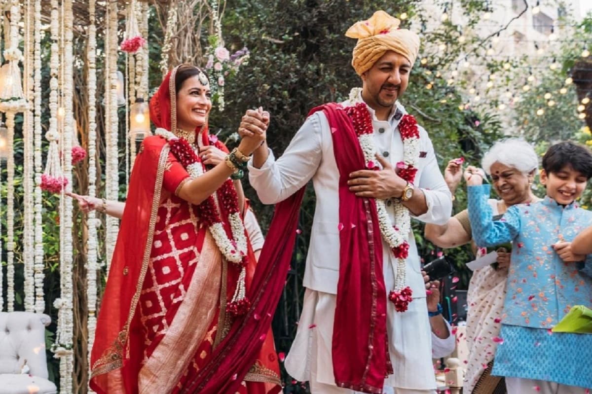 নায়িকার বিয়ে উপলক্ষ্যে যতটা না হলেই নয়, সেই মতো সেজে উঠেছে বেল এয়ার অ্যাপার্টমেন্টের বাগানে তৈরি বিবাহমণ্ডপ। পূর্ণ কলসের মঙ্গলময় স্তম্ভে ঘেরা মণ্ডপে পরস্পরের গলায় মালা পরিয়ে দিয়েছেন দিয়া আর বৈভব। নায়িকার বিয়ে উপলক্ষ্যে যতটা না হলেই নয়, সেই মতো সেজে উঠেছে বেল এয়ার অ্যাপার্টমেন্টের বাগানে তৈরি বিবাহমণ্ডপ। পূর্ণ কলসের মঙ্গলময় স্তম্ভে ঘেরা মণ্ডপে পরস্পরের গলায় মালা পরিয়ে দিয়েছেন দিয়া আর বৈভব।