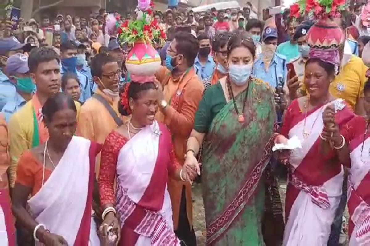 *ধামসা মাদলের তালে ছন্দ মিলিয়ে নাচতে দেখা যায় তাঁকে। শুরুর দিকে অন্যান্য আদিবাসী নৃত্য শিল্পীদের কাছে তিনি জানতে চান তাঁর নাচ সঠিক হচ্ছে কিনা। পরে এক আদিবাসী নৃত্য শিল্পীর কাছ থেকে মাথার মাটির কলসি নিয়ে নিজের মাথায় রাখেন স্মৃতি। কলসি মাথায় নাচের সময় ভারসাম্য হারিয়ে একবার কলসি পরে যাওয়ার উপক্রম হয়। কিন্তু, সুকৌশলে কলসি ধরে নিয়ে এরপর মাথায় কলসি ধরে রেখেই নাচতে দেখা যায় তাঁকে। *ধামসা মাদলের তালে ছন্দ মিলিয়ে নাচতে দেখা যায় তাঁকে। শুরুর দিকে অন্যান্য আদিবাসী নৃত্য শিল্পীদের কাছে তিনি জানতে চান তাঁর নাচ সঠিক হচ্ছে কিনা। পরে এক আদিবাসী নৃত্য শিল্পীর কাছ থেকে মাথার মাটির কলসি নিয়ে নিজের মাথায় রাখেন স্মৃতি। কলসি মাথায় নাচের সময় ভারসাম্য হারিয়ে একবার কলসি পরে যাওয়ার উপক্রম হয়। কিন্তু, সুকৌশলে কলসি ধরে নিয়ে এরপর মাথায় কলসি ধরে রেখেই নাচতে দেখা যায় তাঁকে।
