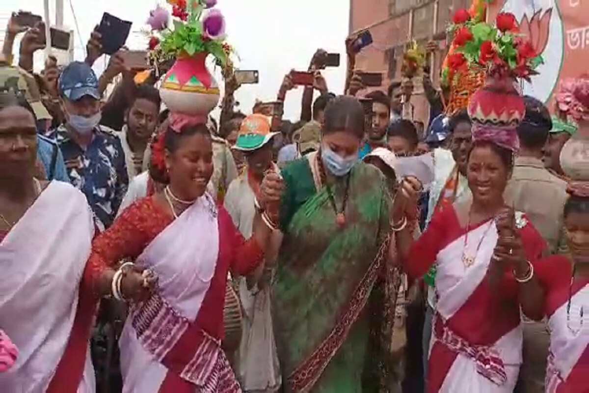 *মন্ত্রী নাচবেন শুনে প্রথমে খানিকটা হতবাকই হন আগে থেকে মজুত আদিবাসী নৃত্যশিল্পীরা। বিজেপির তরফের তাঁদের আনা হয়েছিল কেন্দ্রীয় মন্ত্রীকে স্বাগত জানানোর জন্য। সেই মন্ত্রীই কিনা তাঁদের সঙ্গে নাচবেন! কেন্দ্রীয় মন্ত্রী প্রথমে আদিবাসী মহিলাদের হাত ধরে নাচের তালে পা মেলান। *মন্ত্রী নাচবেন শুনে প্রথমে খানিকটা হতবাকই হন আগে থেকে মজুত আদিবাসী নৃত্যশিল্পীরা। বিজেপির তরফের তাঁদের আনা হয়েছিল কেন্দ্রীয় মন্ত্রীকে স্বাগত জানানোর জন্য। সেই মন্ত্রীই কিনা তাঁদের সঙ্গে নাচবেন! কেন্দ্রীয় মন্ত্রী প্রথমে আদিবাসী মহিলাদের হাত ধরে নাচের তালে পা মেলান।