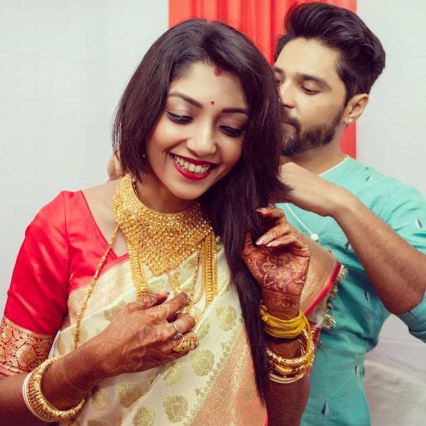 • ছবিতে দেখা যাচ্ছে ঘরোয়া অনুষ্ঠানে সাদা-লাল বেনারসী আর ভারী সোনার গয়নায় সেজেছেন দেবলীনা । গৌরবের পরণে হালকা নীল পাঞ্জাবী ।  ছবি- ইনস্টাগ্রাম ।