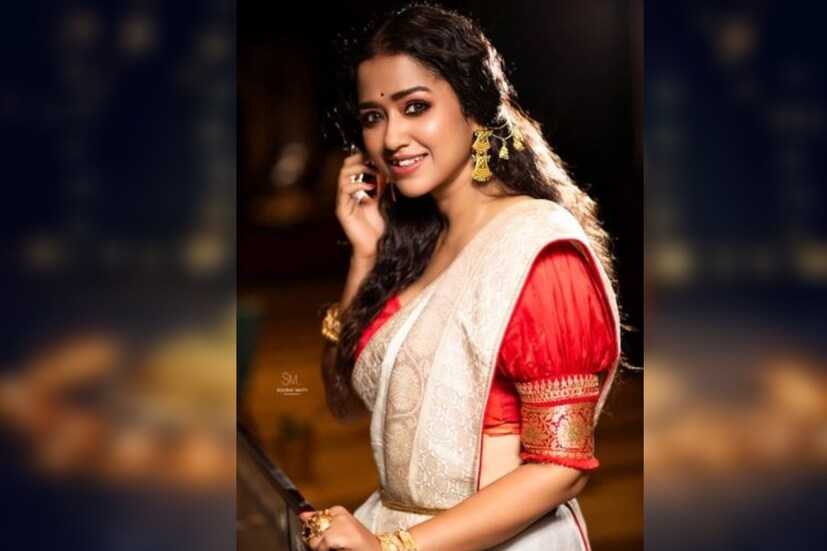 সোহিনী সরকার সাদা শাড়িরসঙ্গে লাল জমকালো ব্লাউজ পরেছেন। পুরো সাজ কালীপুজোর জন্য যথার্থ। 