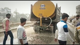ধুলো নিবারন করার জন্য জলের ট্যাংকের গাড়ি দিয়ে জল দেওয়া হচ্ছে রাস্তায়