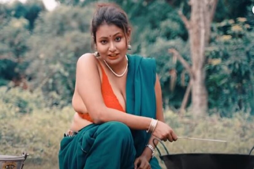 রুই বা কাতলা মাছ ভাজা শেখানো হচ্ছে উদার প্রকৃতির মধ্যে৷ প্রায় নামমাত্র ব্লাউজ, উদ্ভিন্ন যৌবন মেখে মাছভাজা রান্নাও শেখাচ্ছেন মধু৷ Photo Courtesy- Unique Village Food/ Youtube/ Video Grab