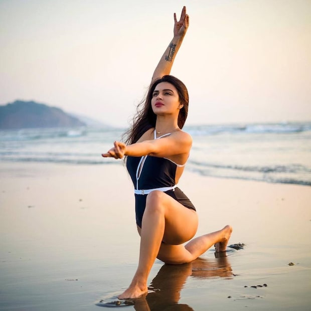 সমুদ্রের ধারে মোনোকিনি পরে যোগ ব্যায়াম আশকার। হাতের ট্যাটু নজর কাড়ছে। 
