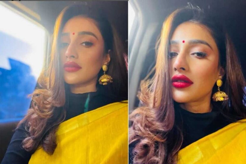 কালো হাইনেক ব্লাউজের সঙ্গে হলুদ শাড়ি। সঙ্গে কানে ঝুমকো। ব্লো ড্রাই হেয়ার ও লিপশেড সাজ পরিপূর্ণ করেছে অভিনেত্রী সায়ন্তিকা বন্দ্যোপাধ্যায়ের। 