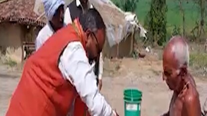 বৃদ্ধের পায়ে তেল মালিশ বিজেপি প্রার্থীর। বৃদ্ধের পায়ে তেল মালিশ বিজেপি প্রার্থীর।