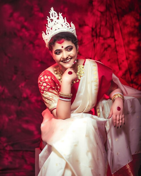 *এ দিন লাল-সাদা বেনারসিতে দেখা মিলল ঐন্দ্রিলার। মাথায় শোলার টোপর, সিঁথিতে সিঁদুর, কপালে লাল টিপ। সোনার হার ও কানের দুল। নাকে বড় নথ। হাতে শাঁখা-পলা, বালা, চুরি। তাহলে কী বিয়ের পিঁড়িতে বসলেন অভিনেত্রী? (ছবি সৌজন্যেঃ ঐন্দ্রিলা শর্মার ফেসবুক পেজ) 
