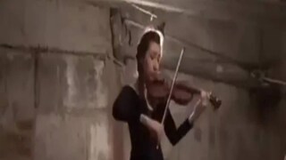 বোমাবর্ষণ থেকে বাঁচতে বাঙ্কারে আশ্রয় নেওয়া তরুণী নিমগ্ন হয়ে বেহালায় ছড় টানছেন