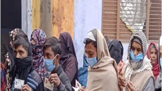 Voters line up outside a polling station in Kairana