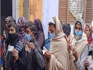 Voters line up outside a polling station in Kairana
