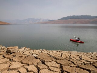 A kayaker fishes in Lake Oroville as water levels remain low due to continuing drought conditions in Oroville, California. (Credits: AP)