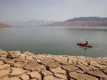 A kayaker fishes in Lake Oroville as water levels remain low due to continuing drought conditions in Oroville, California. (Credits: AP)