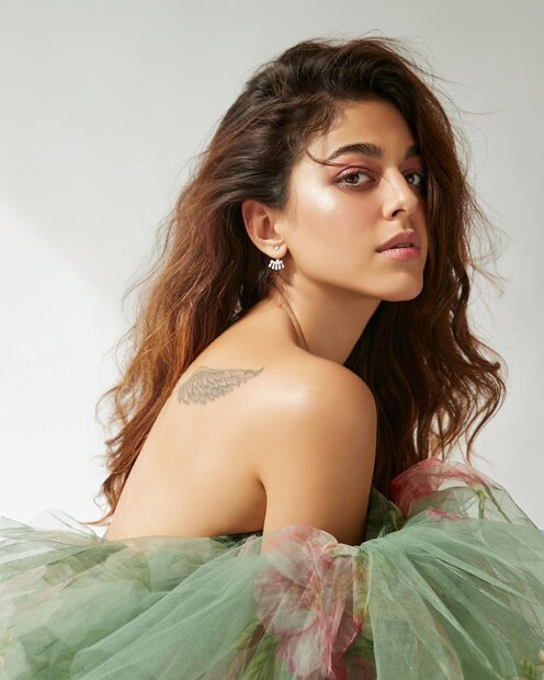 অফ শোল্ডার ড্রেসে পিঠের ট্যাটু দেখা যাচ্ছে। 