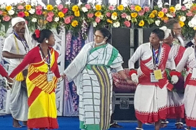 আলিপুরদুয়ার সফরের শেষ দিনে মমতা বন্দ্যোপাধ্যায় (Mamata Banerjee) গণবিবাহের আসরে উপস্থিত হলেন। শুধু তাই নয়, ধামসা-মাদলের তালে আদিবাসী নাচের ছন্দে মেতে উঠতেও দেখা গেল তাঁকে। এরপর সরকারি প্রকল্পের উদ্বোধন ও শিলান্যাসের অনুষ্ঠানেও অন্য মেজাজে দেখা গেল মুখ্যমন্ত্রীকে। 