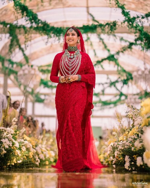 ঘন লাল রঙের নেটশাড়ি ও এলানো ওড়নায় সেজেছিলেন বিয়ের কনে নয়নতারা৷ সঙ্গে ছিল হিরে ও পান্নার নজরকাড়া অলঙ্কার৷