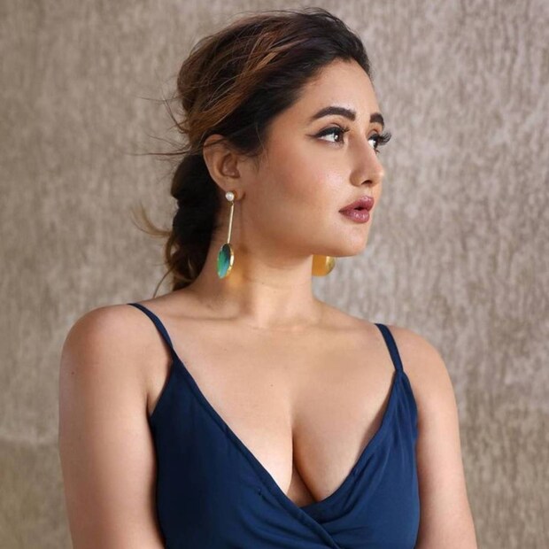 নীল পোশাকের ফাঁকে দর্পিত স্তন৷ কানের দুল তাঁর স্টাইল স্টেটমেন্ট৷