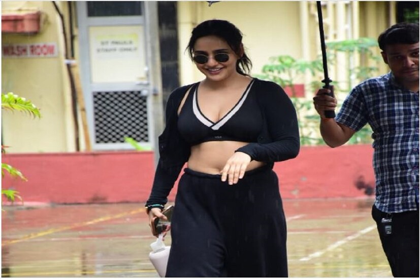 কালো স্পোর্টস ব্রা, কালো ঢোলা ট্র্যাক প্যান্ট-এর সঙ্গে নেহা টিম-আপ করেছেন কালো শ্রাগ