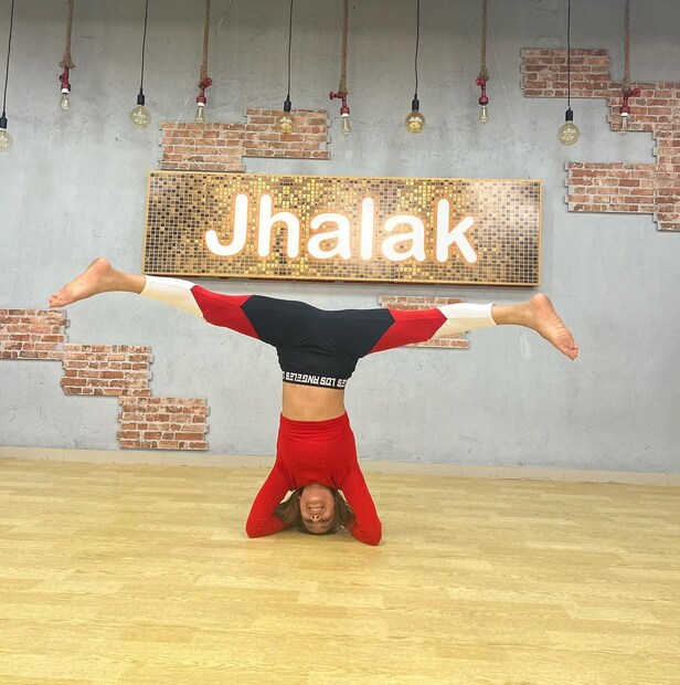 লাল ক্রপ টপ ও রঙিন লেগিংসে নিয়ার স্প্লিট। 