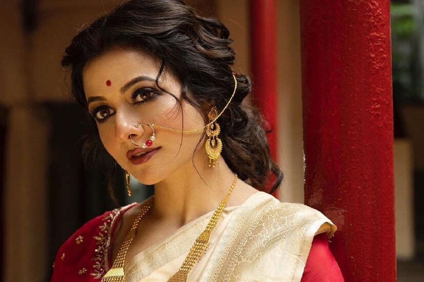 গাঢ় লাল এমব্রয়ডারি করা ব্লাউজ এবং গরদের শাড়িতে কোয়েলকে একেবারেই মোহময়ী দেখাচ্ছে। সঙ্গে রয়েছে মোটা কাজল, লাল টিপ, লাল সিঁদুর, শাখা-পলা, সোনার গয়না, একেবারেই বাঙালি আটপৌরে মেজাজে নায়িকা। সবচেয়ে নজর কেড়েছে নাকের নথটি, নজর ফেরানো যাচ্ছে না অভিনেত্রীর থেকে। 