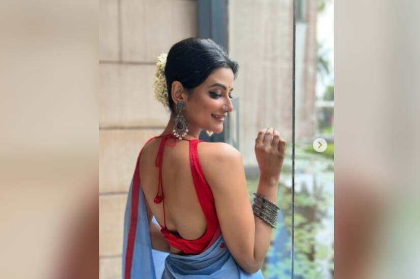 মোহময়ী রূপে সামনে এলেন উষসী রায়। পিঠ কাটা ব্লাউজ, নীল শাড়িতে নজরকাড়া নায়িকা। মাথায় গুঁজেছেন ফুল। হাতে, কানে রুপোর গয়না।