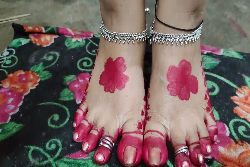  রাঙা সূর্য: এই নকশা দেখে মনে হবে যে, হাত-পায়ের পাতার মধ্যিখানে যেন সূর্যোদয় হয়েছে! আর এই নকশা সাবেকিয়ানায় মোড়া এবং চিরন্তনও বটে। সূর্যের এই নকশা আঁকার জন্য পায়ের পুরো আঙুল এবং তার আশপাশের অংশ ভরাট করে নিতে হবে। আর এর পর পায়ের পাতার মাঝ বরাবর বড় করে একটা বৃত্ত এঁকে তা ভরাট করে নিতে হবে। আলতায় ভরাট করা সেই বৃত্তের চারপাশে লাল টিপ এঁকে নিতে হবে। এই বিশেষ ডিজাইনে পায়ের সৌন্দর্য কয়েক গুণ তো বেড়ে যায়ই। সেই সঙ্গে আসে সাবেকি লুকও। হাতের ক্ষেত্রেও একই রকম ভাবে ডিজাইন আঁকতে হবে। শুধু আঙুলের নখের মাথা থেকে নিচের দিকের তিনটে কড় আলতা দিয়ে ভরাট করে নিলেই হবে।