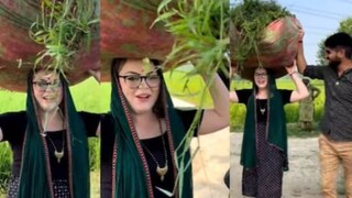 সেখানে দেখা যাচ্ছে স্বামীর পাশে মাথায় ঘাসের বোঝা নিয়ে এগিয়ে যাচ্ছেন ওই অস্ট্রেলীয় তরুণী