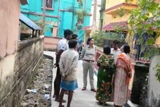  বাড়ির সামনে পুলিশ ও প্রতিবেশীরা দাঁড়িয়ে আছে