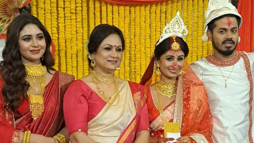 ঋতাভরীর শাড়ির সঙ্গে ডান কাঁধে ছিল সরু সোনালি পাড়ের লাল ওড়নাও। লেহঙ্গার ভারি সোনালি কাজের পাশে ঢালা লাল শাড়ি যেন চোখের আরাম। আর ছিল গলা ভরা সোনার হার। কানে ছিল ভারি দুল আর হাতে মান্তাসা।