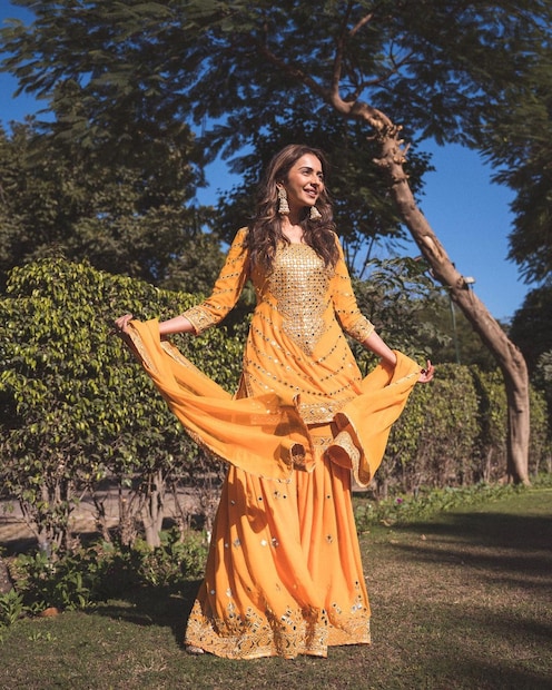 উজ্জ্বল কমলা রঙের শারারা ও কুর্তা পরেছেন নায়িকা। 