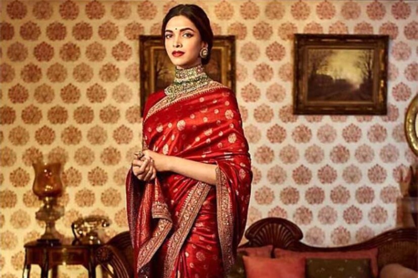 দীপিকা পাড়ুকোন: বিয়ের মরশুমের কথা যখন উঠল, তখন বেনারসি দিয়েই শুরু করা যাক। দীপিকা একটি লাল বেনারসি সিল্ক পরেছিলেন, আঁচল নিয়েছিলেন বাঁ হাতে খুলে। সারা শরীরে রুপোলি জরির ভরাট কাজ। ভারী কানবালা আর নেকলেসে জমকালো সাজেও কোথাও আড়ম্বর ধরা পড়ছে না। যেন হালকা হাওয়ার মতো সহজ।