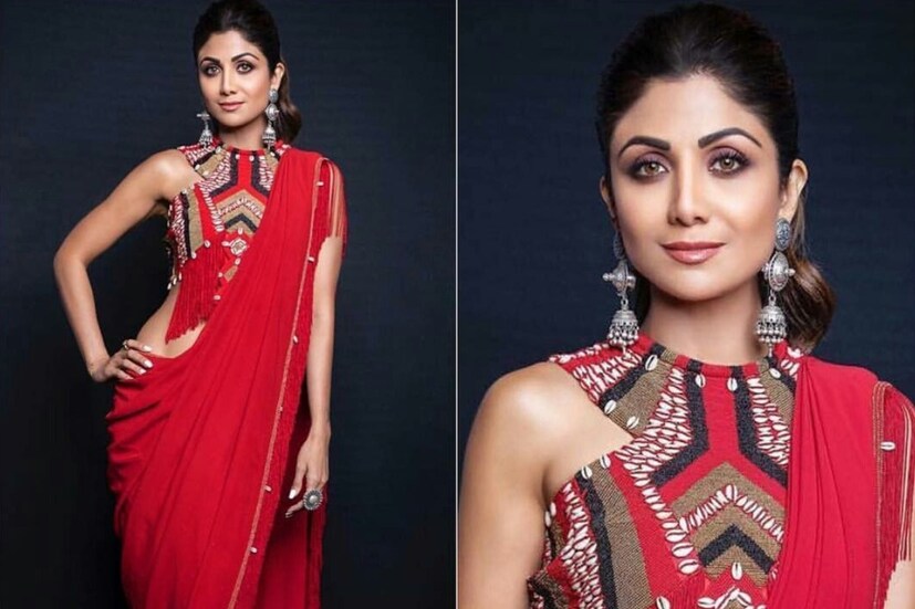 শিল্পা শেঠি: শিল্পার লাল শাড়িটি সকলের থেকে আলাদা। আসলে প্রায় একটি লাল থানের উপর বিডসের কাজ করা রয়েছে শাড়ির পাড়ে। একেবারে ট্রাইবাল লুক দিতে শিল্পা এর সঙ্গে বেছে নিয়েছেন বিডসে কাজ করা চোলি। আর কানে রুপোর ভারী গয়না, যার মধ্যেও রয়েছে আদিবাসী ছাপ। মোহময় এই রূপ যে অন্যদের থেকে খানিকটা আলাদা করে দেবে শাড়ির মালকিনকে তা তো বোঝাই যাচ্ছে।