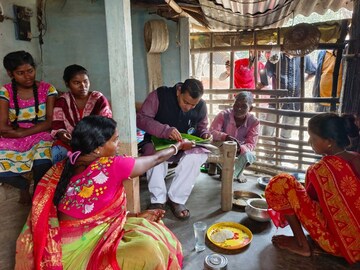 আদিবাসী পরিবারে ঢুকে পিঠে খেলেন রাজ্যের প্রাণিসম্পদ উন্নয়ন দফতরের মন্ত্রী স্বপন দেবনাথ