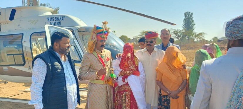 এই যেমন, রণবীর সিং-ই লেক কোমোয় দীপিকা পাড়ুকোনকে বিয়ে করতে এসেছিলেন হেলিকপ্টারে চড়ে। সে ছিল নায়কের নিজের ইচ্ছা। আর এবার রাজস্থানের নাগৌর জেলার রিয়ান বাড়ি তহসিলের বংশওয়াড়াতেও দেখা গেল এক দৃশ্য- হেলিকপ্টার থেকে নামলেন বিয়ে করতে রবিন সিং রাজাওয়াত। তফাত এই- যে তাঁর শ্বশুরের ইচ্ছাপূরণ!