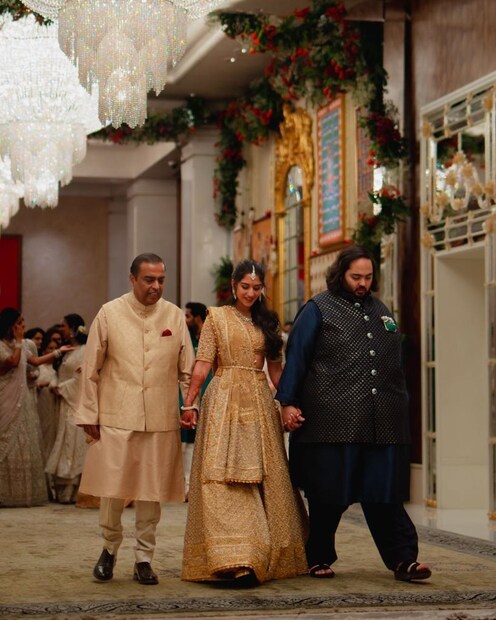  ইতিমধ্যেই সকলে হয়তো জেনে গিয়েছেন কে এই দম্পতি! তা-ও আরও এক বার দিয়ে নেওয়া যাক রাধিকা-অনন্তের পরিচয়। রিলায়েন্স ইন্ডাস্ট্রিজের চেয়ারম্যান মুকেশ আম্বানি এবং তাঁর স্ত্রী নীতা আম্বানির ছোট ছেলে হলেন অনন্ত আম্বানি। তিনি পড়াশোনা করেছেন আমেরিকার ব্রাউন বিশ্ববিদ্যালয় থেকে। বর্তমানে তিনি রিলায়েন্স ইন্ডাস্ট্রিজ লিমিটেডের এনার্জি ডিভিশনের একজিকিউটিভ ইন চার্জের দায়িত্ব সামলাচ্ছেন। শুধু তা-ই নয়, জিও প্ল্যাটফর্মস এবং রিলায়েন্স রিটেল ভেঞ্চার্সের বোর্ডেও রয়েছেন তিনি। গত বছরের অগাস্ট মাসেই নিজের উত্তরাধিকার পরিকল্পনা প্রকাশ্যে এনেছিলেন মুকেশ আম্বানি। তাঁদের ব্যবসার টেলিকম এবং রিটেলের লিডারশিপ দায়িত্ব পেয়েছেন যমজ সন্তান আকাশ এবং ইশা। আর ছোট ছেলে অনন্ত আম্বানিকে কোম্পানির নতুন এনার্জি সেক্টরের দায়িত্ব দিয়েছেন মুকেশ।