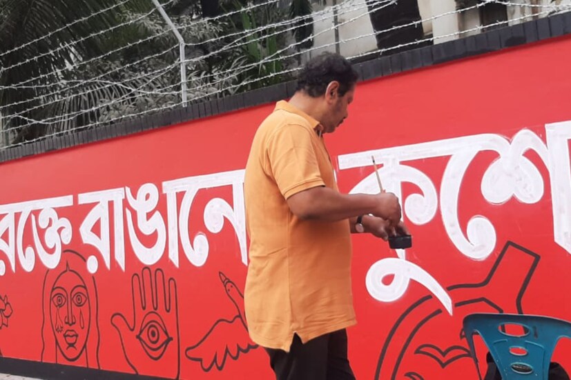 তার পর রাত ৩টের পর থেকেই সর্বসাধারণের জন্য খুলে দেওয়া হয় এই শহিদ মিনার প্রান্তর। ১৯ তারিখ শহিদ মিনারের সামনের দেওয়ালে ছবি আঁকলেন শিল্পী শিশির ভট্টাচার্য। ২০ তারিখ বিকেল পর্যন্ত রাস্তায় আল্পনা দেওয়া হয়েছে। স্কুলের স্কাউট দলের ছাত্রছাত্রীরা ফুল দিয়ে সাজিয়েছেন মিনারের পাদদেশ। (ছবি: কামরুল হাসান মিথুন)