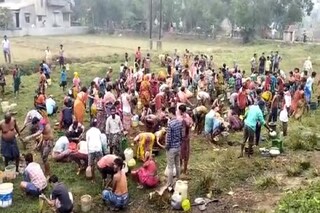 উল্টে পড়া ট্রাকের তেল কুড়োতে শুক্রবার সকাল থেকে হুড়োহুড়ি পড়েছে স্থানীয় মানুষদের