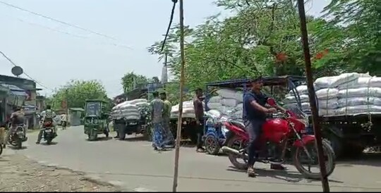 রাস্তার ধারে লাইন দিয়ে দাঁড়িয়ে সারি সারি রেশনের আটার বস্তা বোঝাই গাড়ি 