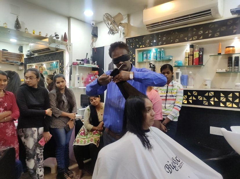 জানা যায়, এই ব্যক্তি চোখ বেঁধে টানা ১২ ঘণ্টা চুল কেটেছেন। এবং চোখ বেঁধে তিনি যে স্টাইলে চুল কাটেন তাতে দারুণ খুশি সকলে। এমনকি এর জন্য অনেক পুরস্কার পেয়েছেন তিনি। (Reported By: Gayatri Chauhan)