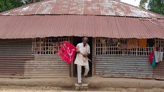 নিজের কুঁড়েঘর থেকে বেরোচ্ছেন হাতে দলের পতাকা নিয়ে