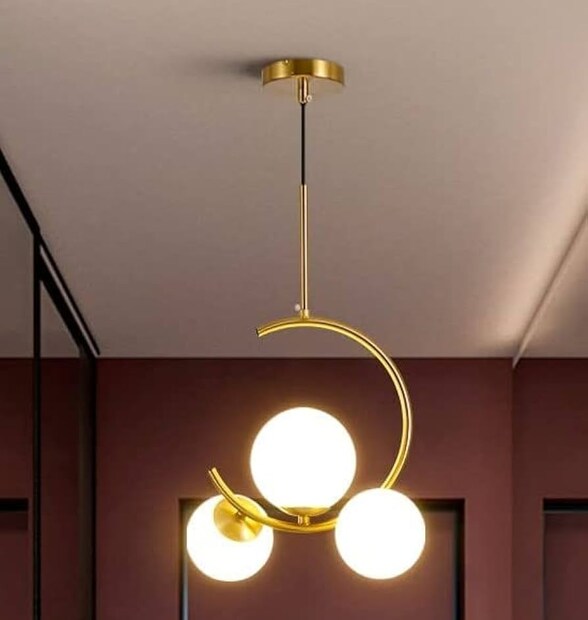 Desidiya® 3-Light Globe Chandelier Hanging Light হ্যাঙ্গিং এই আলোয় ফুটে উঠেছে এক অনন্য গোলাকার নকশা। উচ্চ মানের ধাতু দিয়ে তৈরি এই আলোয় দেওয়া হয়েছে গোল্ড ফিনিশ। ঘর বড় হলে এই আলো দারুণ মানাবে। অনেকটা ঝাড়বাতির মতো এই আলো ঘরের প্রতিটি কোণে ছড়িয়ে দেবে উজ্জ্বলতা। সেই সঙ্গে অন্দরসাজের মাত্রাই যেন বদলে দেবে।
