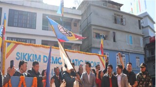 পবন চামলিংয়ের হাত থেকে দলীয় পতাকা নিচ্ছেন বাইচুং৷ 