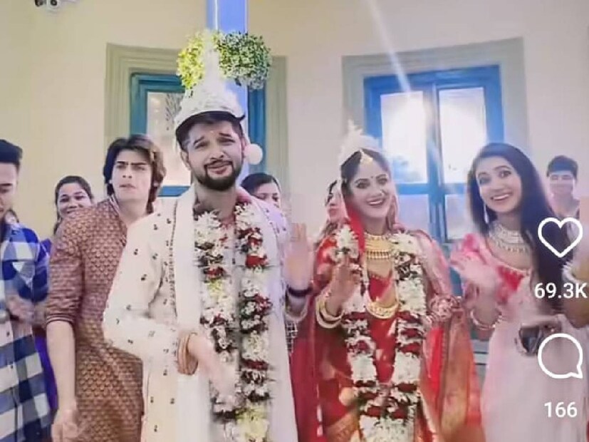 লাল টুকটুকে বেনারসিতে সেজে উঠেছেন তৃণা। সঙ্গে মানানসই গয়না। গলায় মালা। একেবারে যেন নববধূ। পিছিয়ে নেই নীলও। ধুতি-পাঞ্জাবি-টোপরে নজর কাড়ছে তিনিও। তা হলে কি আরও একবার বিয়ের পিঁড়িতে বসলেন তাঁরা?