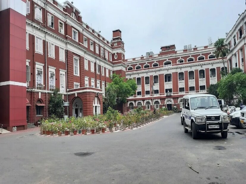'অষ্টাদশ শতকের শেষের দিকে লালবাজার এলাকায় ব্রিটিশরা অনেকটা সময় কাটাতেন। তখনকার বিখ্যাত রিসর্ট ‘হারমোনিক ট্যাভার্ন’ অবস্থিত ছিল মূল বাড়িটির গা ঘেঁষে।উচ্চবিত্ত ইংরেজ নারী-পুরুষের কাছে তুমুল জনপ্রিয় ছিল এই ট্যাভার্ন, যা সুর এবং সুরায় জমজমাট হয়ে উঠত প্রতি সন্ধ্যায়। ওয়ারেন হেস্টিংস-এর ফেয়ারওয়েল পার্টি আয়োজিত হয়েছিল এখানেই। 'লাল'-এর উৎস সন্ধানে পুরনো নথিপত্রে ‘loll’ শব্দটিও পাওয়া গেছে, যা ‘loll shrub’-এর অপভ্রংশ। ‘লল শ্রব’ বা লাল সুরা। এই সূত্র ধরেই উল্লেখ পাওয়া যায় ' loll bazar’-এরও। নানা মত। তবে যতই থাক মতানৈক্য, রং-এর বিচারে যে নামের উদ্ভব নয় লালবাজারের, অনুমান করাই যায়। শেষ বিচারে উৎস সন্ধান অমীমাংসিতই। অবশ্য নামে কী-ই বা এসে যায়?'